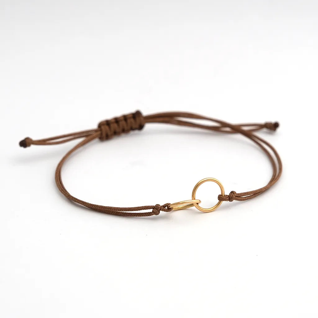 armband_aus_nylonband_braun_geknotet_an_mittelteil_2_ringe_ineinander_gehaengt_gelbgold